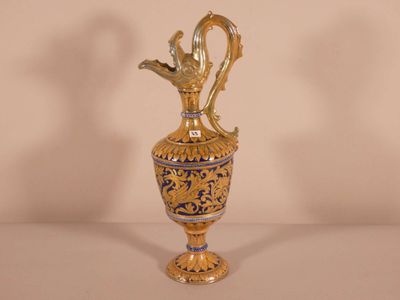 a gold vase with a bird on it on a table