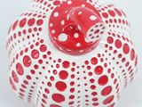 a red and white vase with polka dots on it