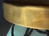 a gold plate with a chain around it on a table