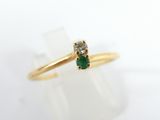 a close up of a gold ring with a green stone