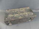 an old metal box with writing on it sitting on a table