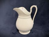 a white pitcher that is sitting on a table