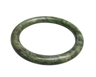 un gros plan d'un bracelet vert sur fond blanc