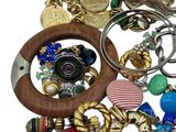 a pile of assorted bracelets and rings on a white surface