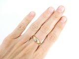 a woman ' s hand with a gold ring on it