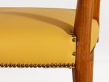 a close up of the back of a chair with a yellow leather seat