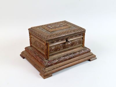une boîte en bois ornée de sculptures sur un fond blanc