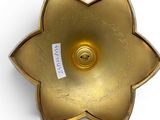 brass flower shaped candle holder with a label on it