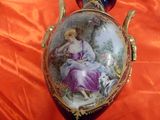 a vase with a picture of a woman and a dog on it