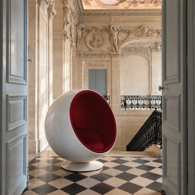 une chaise boule rouge et blanche au milieu d'une pièce