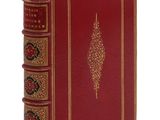 Le livre est rouge, avec des bordures dorées et un motif décoratif.