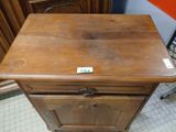 a wooden cabinet with a drawer on top of it