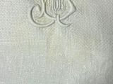 un gros plan sur une serviette blanche ornée d'un monogramme