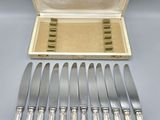a set of six silverplated flatware knives and a case