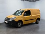 La camionnette jaune est garée dans une grande pièce aux murs blancs.