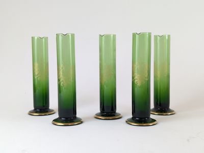 trois vases en verre vert posés les uns à côté des autres sur une surface blanche
