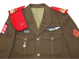 an image of a military uniform with a red tie and a badge on it