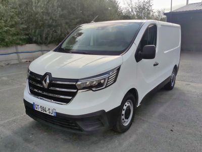 la camionnette blanche est garée dans un parking près d'un bâtiment