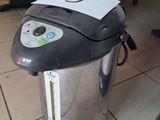 a silver and black coffee maker sitting on the floor