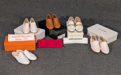 plusieurs paires de chaussures blanches et une boîte posées sur un tapis