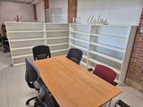 a table and chairs in a room with a bookcase