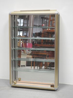 a glass display case with a mirror on the wall