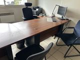 a desk with two chairs and a computer on top of it