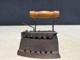 an old iron with a wooden handle on a table