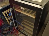 a small refrigerator with a wine cooler inside of it