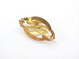 an image of a gold leaf brooch on a white background