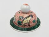 a small bowl with a horse on it and a ball on top