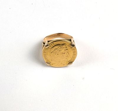 l'image d'une bague en or sur laquelle se trouve une pièce de monnaie