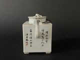a small white box with writing on it on a black surface