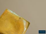 a piece of yellow paper that is sitting on top of a piece of wood