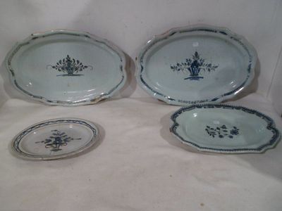 four pieces of blue and white porcelain dishes on a white surface