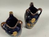 pair of blue and gold vases sitting on a white surface
