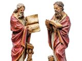 deux figurines représentant deux hommes avec un chien et un livre