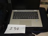 a laptop computer sitting on top of a desk next to a bag