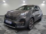une voiture grise est garée dans une grande pièce au sol en damier