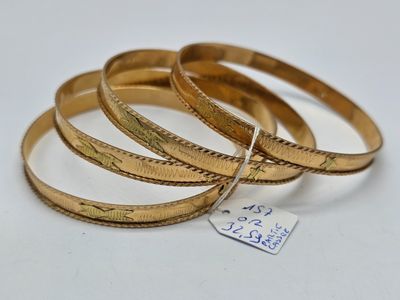 trois bracelets rigides en or, surmontés d'une étiquette