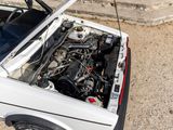 a white car with the hood open and the engine in the trunk