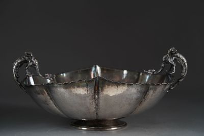 an antique silver bowl with a dragon handle on a pedestal