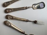 four silver spoons and a fork on a white surface