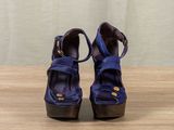 a close up of a pair of blue shoes on a wooden table