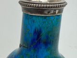 a blue vase with a silver lid sitting on a table
