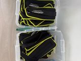 two plastic containers filled with black and yellow items sitting on top of a wooden floor