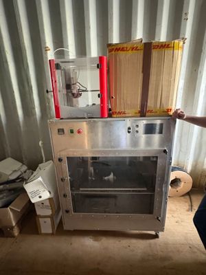 a man standing in front of a machine with boxes on top of it