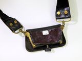 a black and brown purse with a tag on it