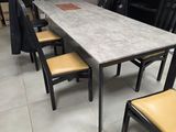 des tables et des chaises dans une grande pièce au sol carrelé de blanc