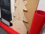 a christmas tree made out of wood next to a red roll of felt